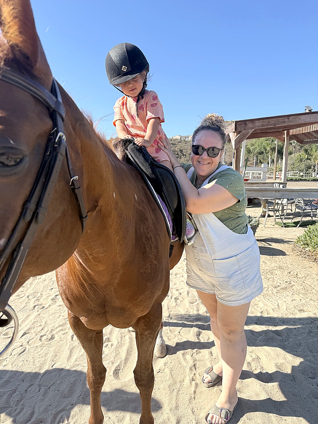 A volunteer steadies a small rider on Calla